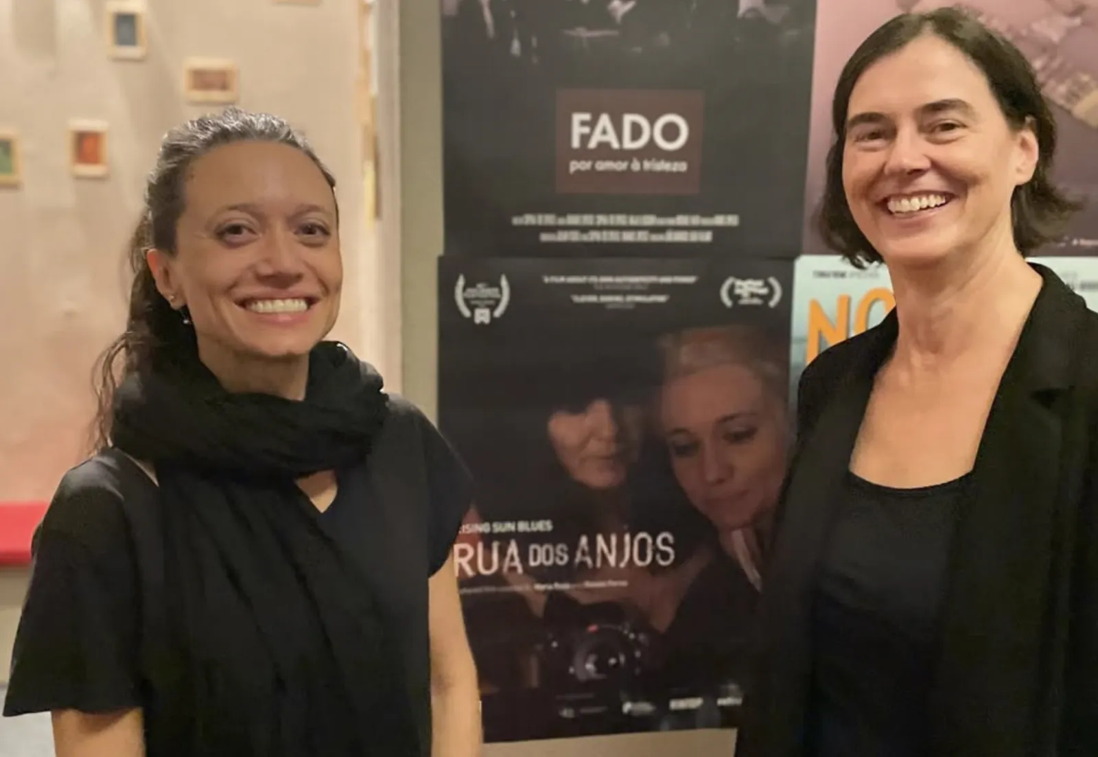 Gäste vor den Festivalplakaten, darunter Rua dos Anjos